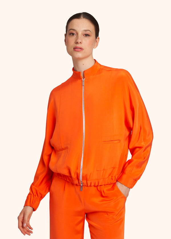 Kiton bomber en soie de couleur orange pour femme.